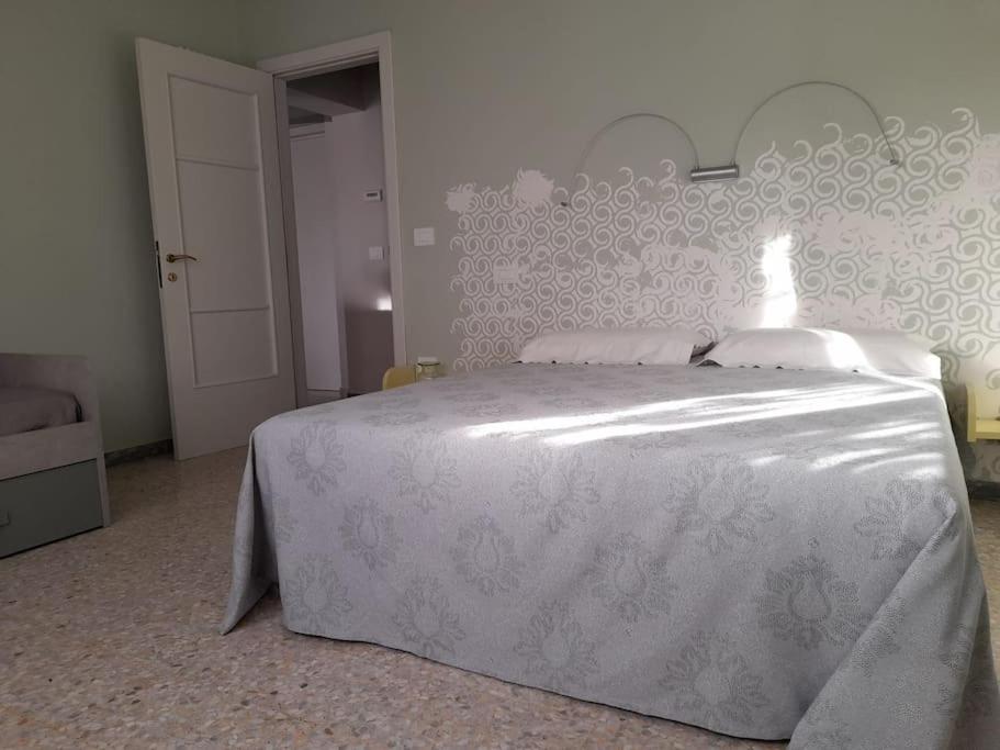 una camera con un letto bianco con una lampada di Il garusolo a Pineto