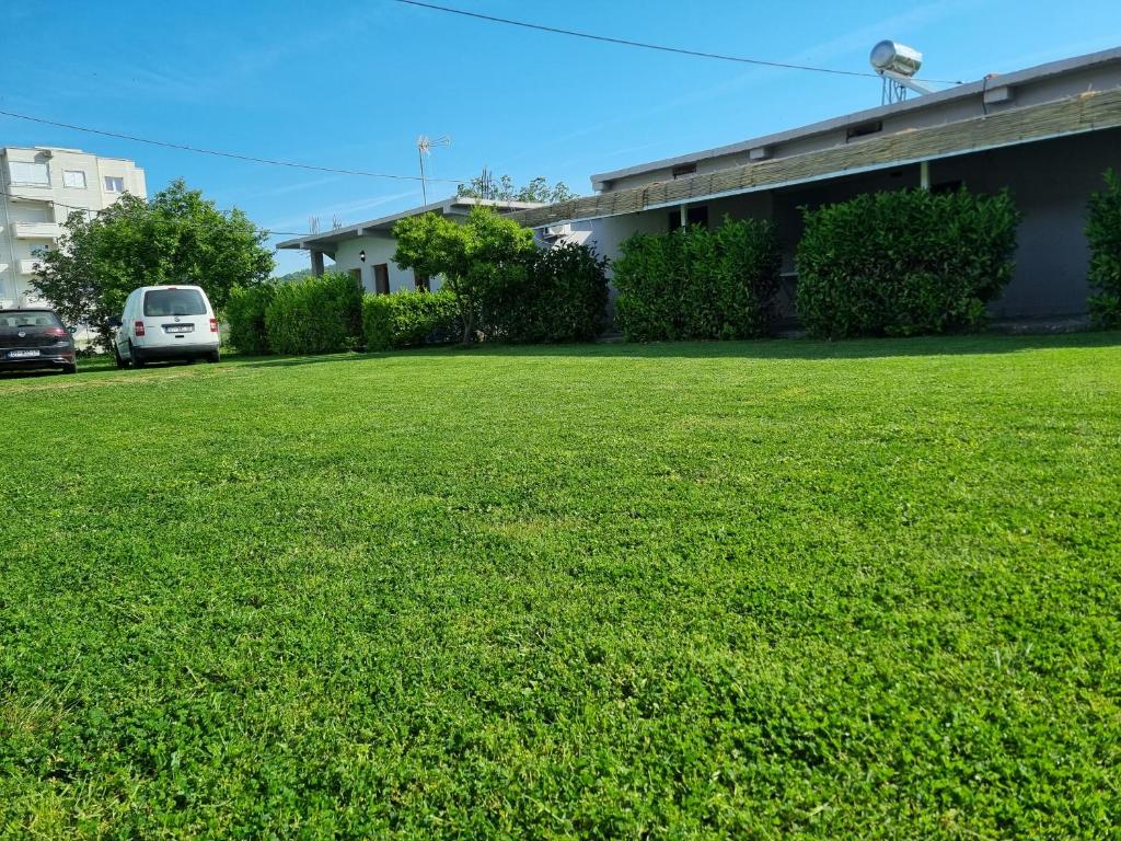 a green lawn in front of a building at HOLIDAY HOME in Durrës