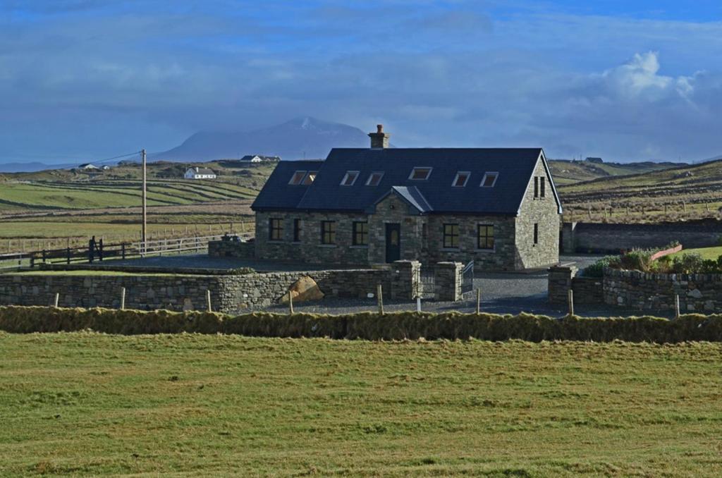 a large stone house in the middle of a field at Cottage 147 - Renvyle in Renvyle