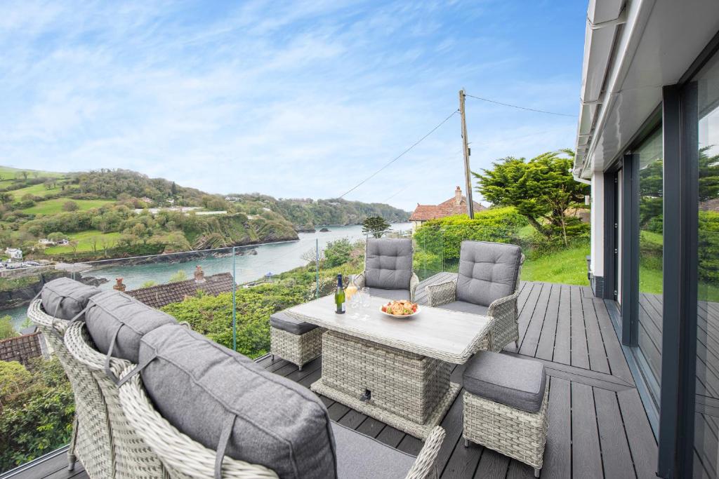 a patio with a table and chairs and a view of a river at Beach View in Ilfracombe