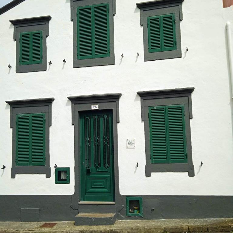 biały budynek z zielonymi drzwiami i oknami w obiekcie Casa Elias w mieście Nordeste