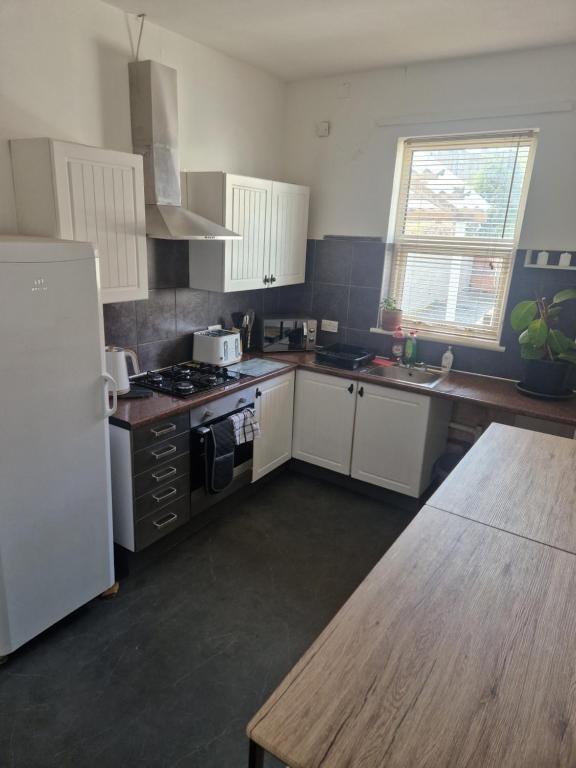 a kitchen with white cabinets and a stove top oven at 13 Grosvenor House, in Bristol