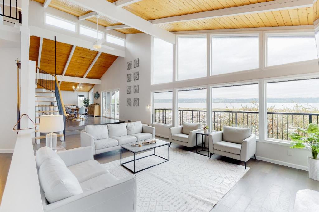 een woonkamer met witte meubels en grote ramen bij Driftwood Waves 