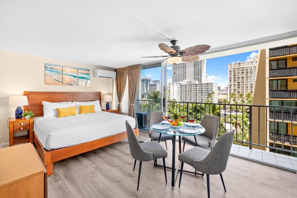 ein Hotelzimmer mit einem Bett und einem Balkon in der Unterkunft Cozy Studio at the Pacific Monarch - Just steps from Beach in Honolulu