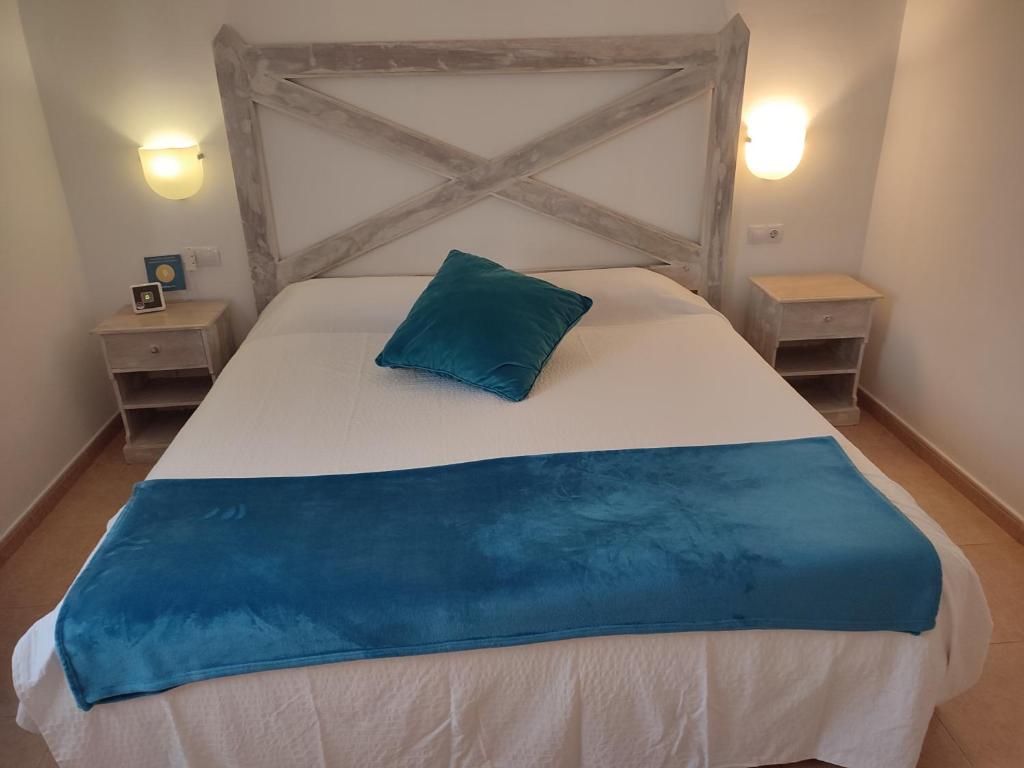 コラレホにあるAppartamento in Oasis tropicaleのベッドルーム1室(大型ベッド1台、青い枕付)