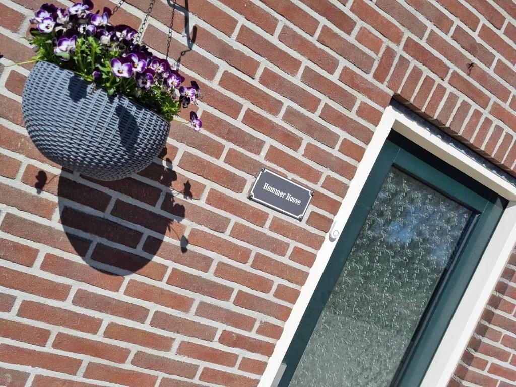 een bloempot aan de zijkant van een bakstenen gebouw bij Hemmer Hoeve in Hem