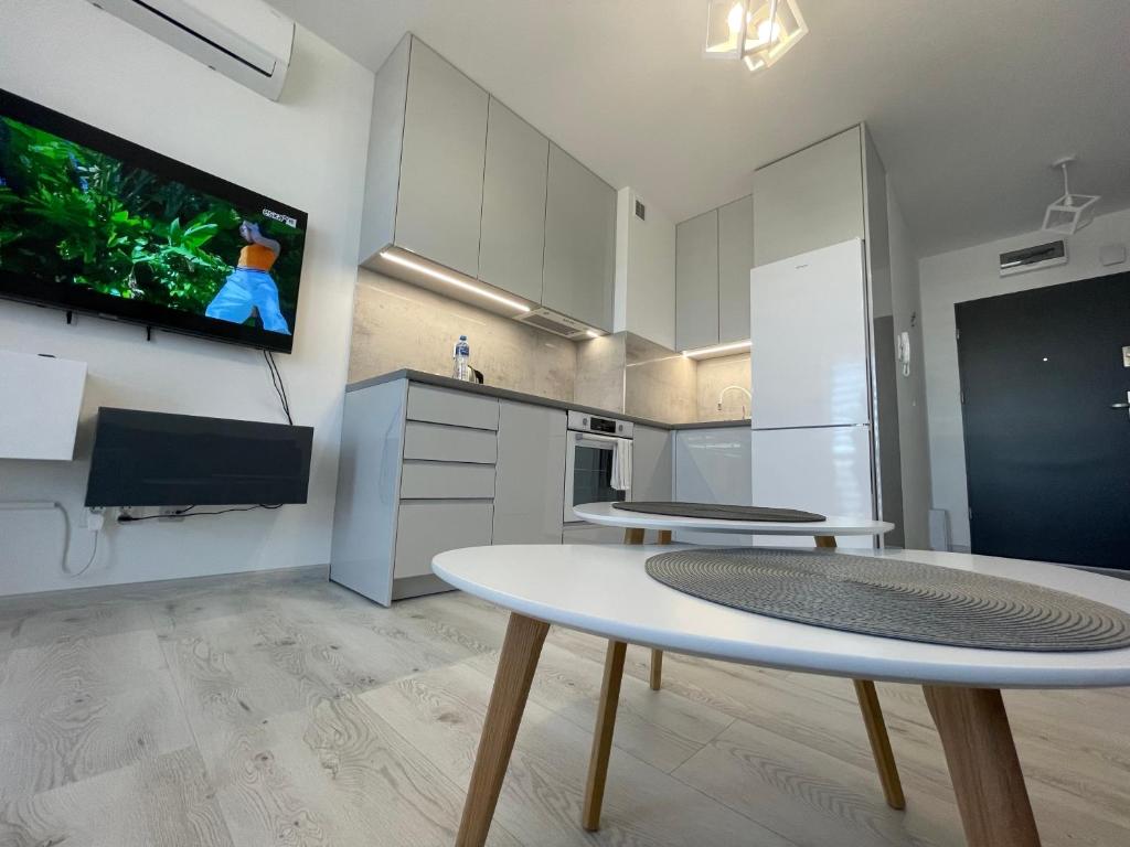 a kitchen with a table and a tv on a wall at N° 60 in Płock