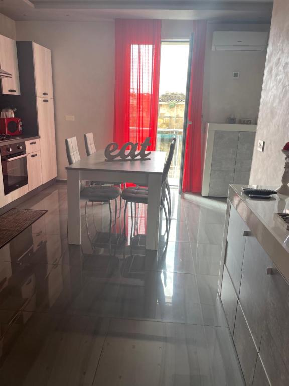 una cucina con tavolo e sedie in una stanza di Deluxe Home appartamento a Sciacca