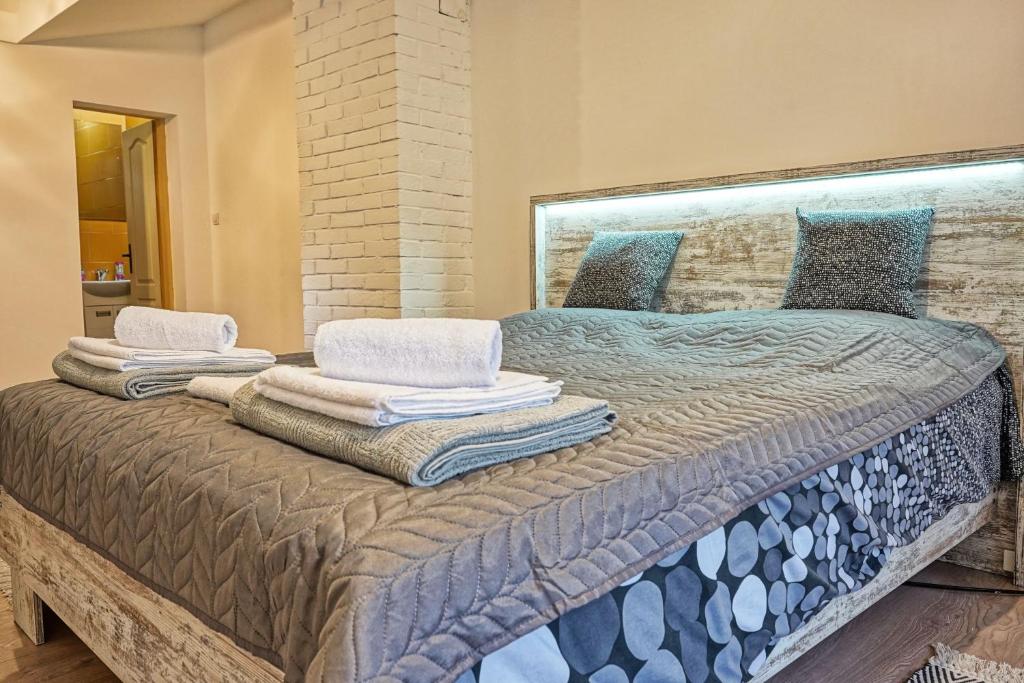 a bedroom with a large bed with towels on it at Zmaj Ognjeni Etno Concept in Kupinovo