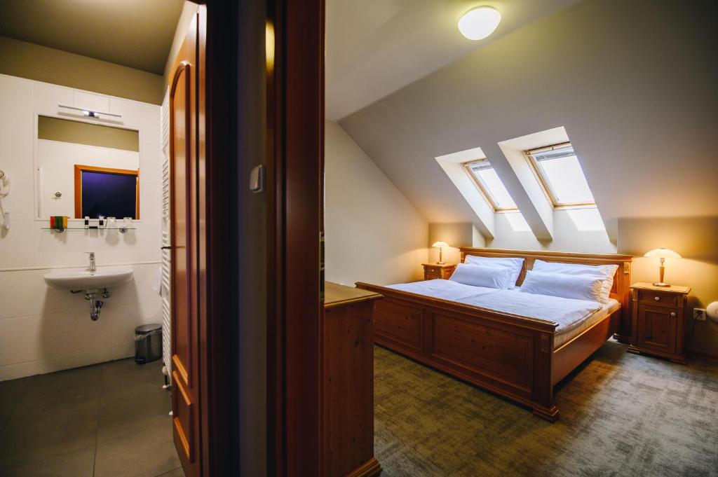 a bedroom with a bed and a bathroom with skylights at Kounický dvůr in Dolní Kounice