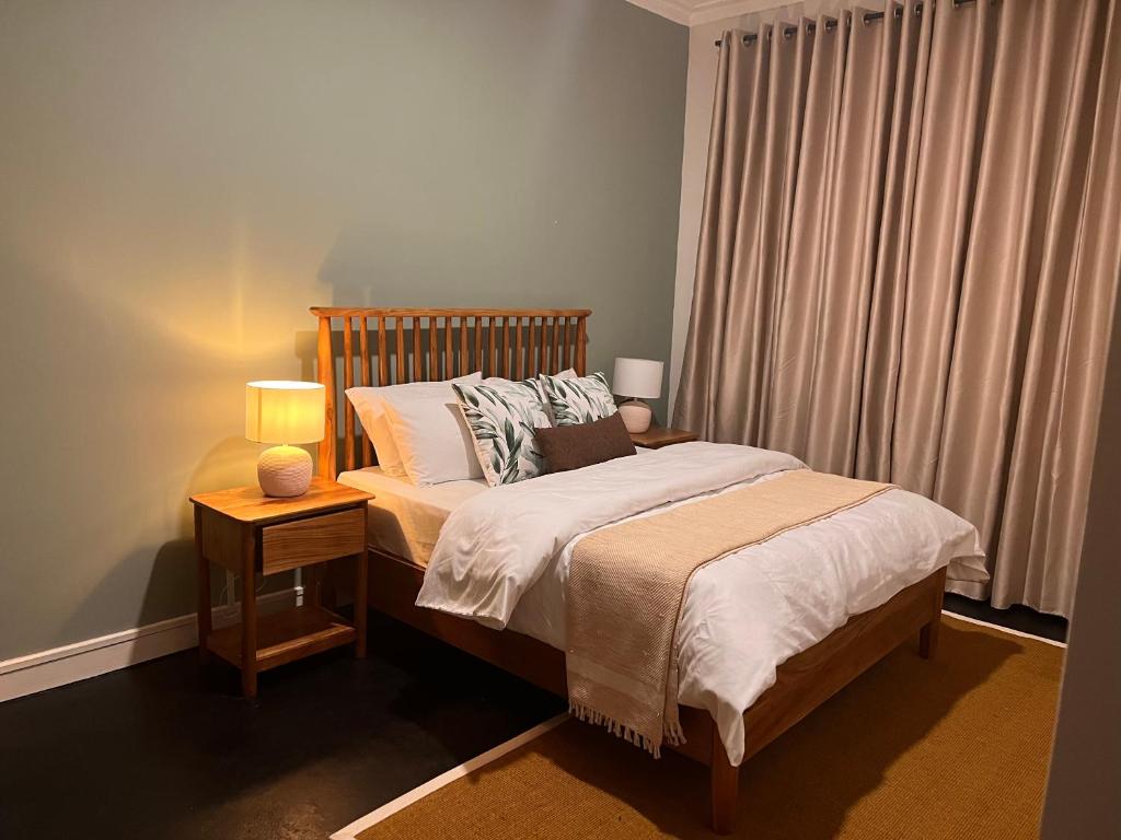 um quarto com uma cama com 2 candeeiros e uma janela em Andrella Home Arusha em Arusha