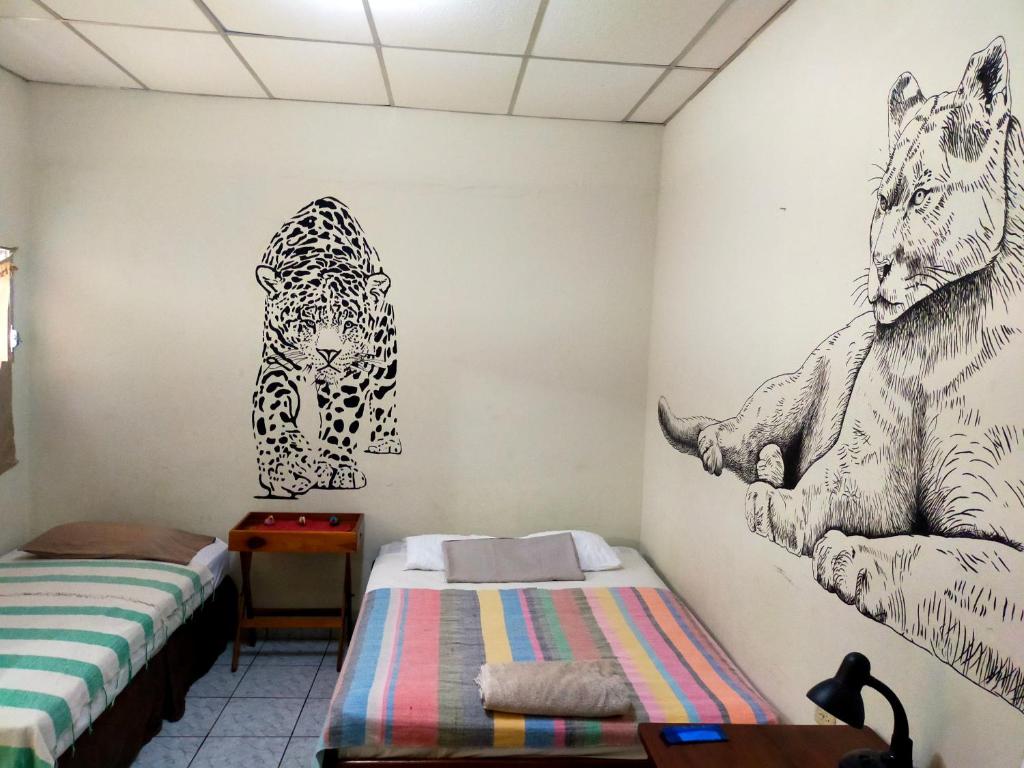 a room with two beds and drawings on the wall at Matagalpa Tours Guest House in Matagalpa