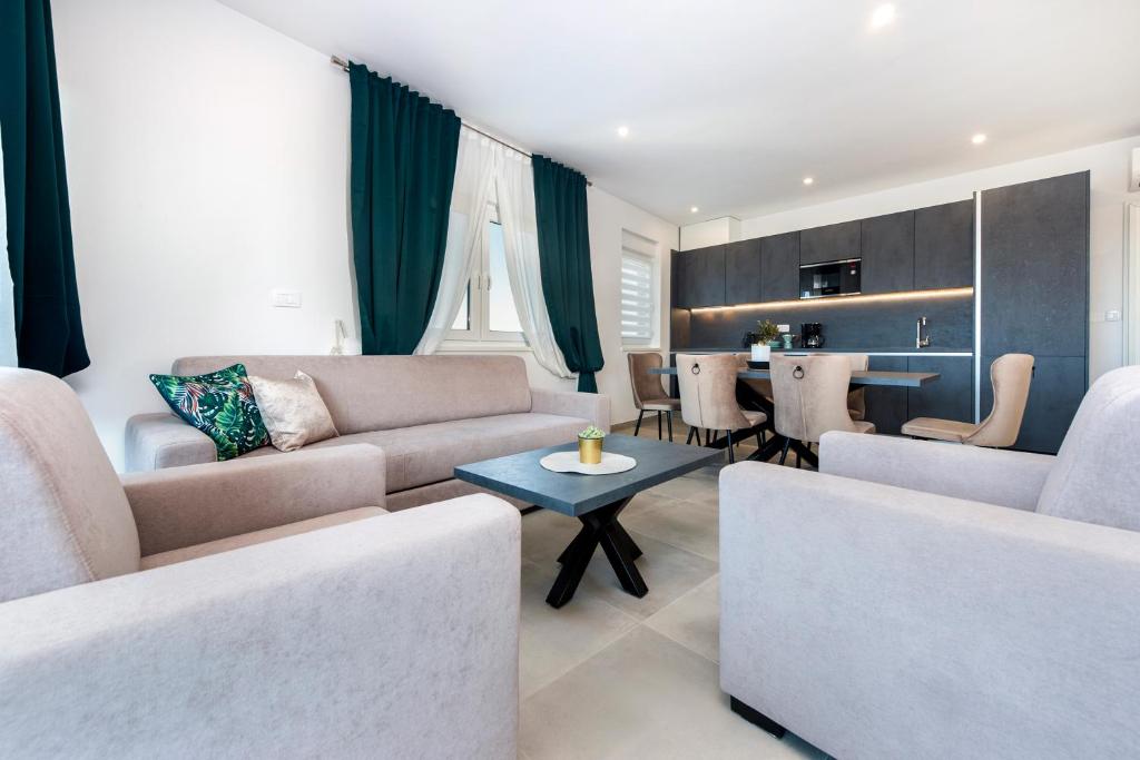 een woonkamer met 2 banken en een tafel bij Grand Suite Cocaletto 2 in Rovinj