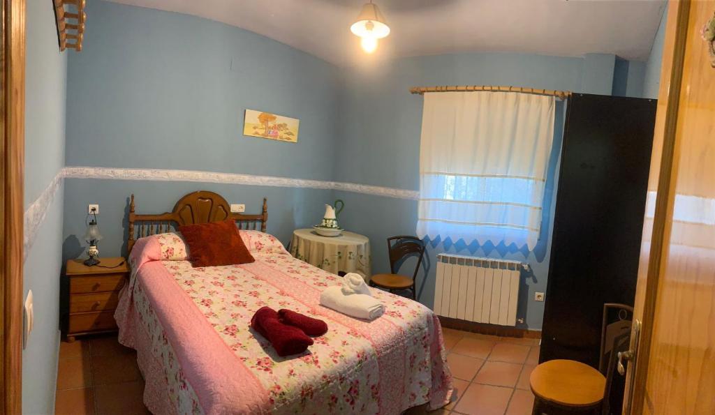 Un dormitorio con una cama con toallas rojas. en APARTAMENTO TURÍSTICO EL ESQUILÓN, en Calzadilla