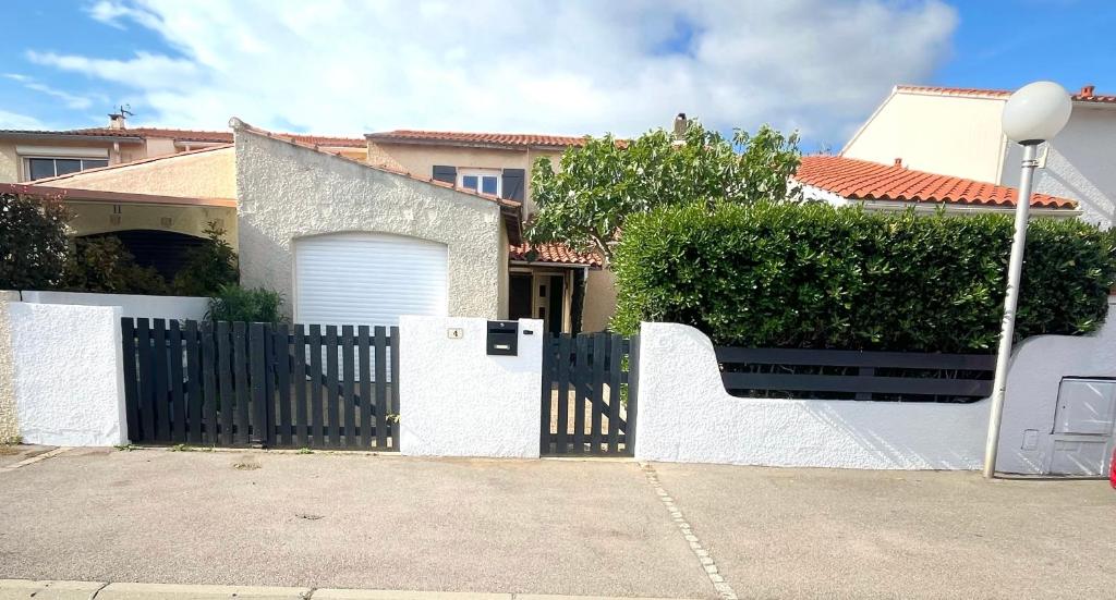 biały płot przed domem w obiekcie Jolie villa familiale w mieście Le Barcarès