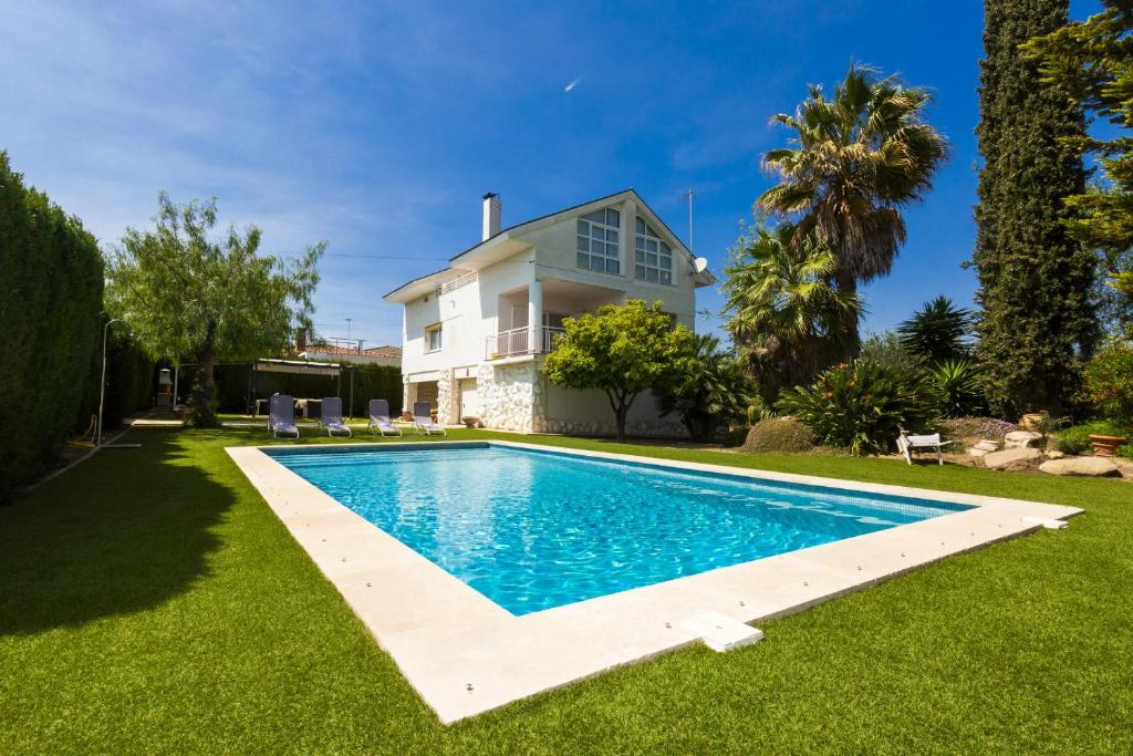 eine Villa mit einem Pool vor einem Haus in der Unterkunft PIZARRA Planetcostadorada in Tarragona