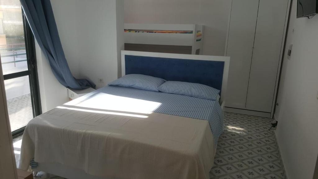een bed met een blauw hoofdeinde in een kamer bij Villa-Hotel Ludianna in Golem
