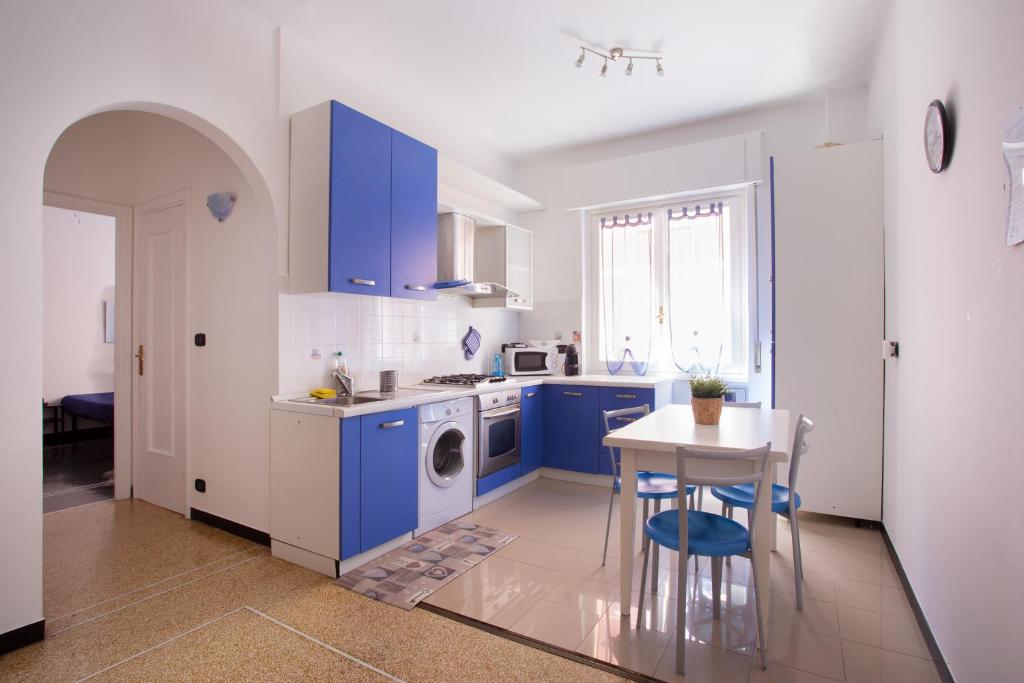 a kitchen with blue cabinets and a table and a sink at La Casetta Blu in Genoa
