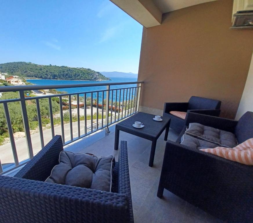 a balcony with chairs and a table with a view of the ocean at Sol in Kremena