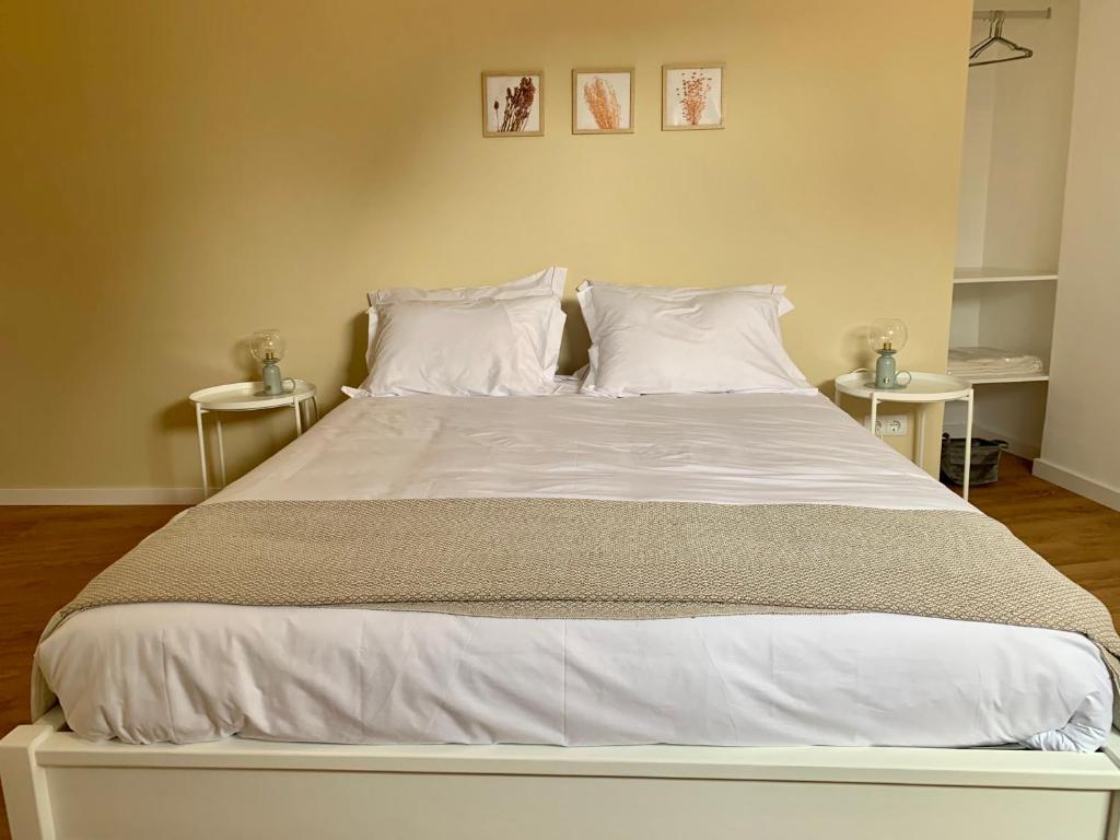 - une chambre dotée d'un grand lit avec des draps et des oreillers blancs dans l'établissement Apartamento Sta Catarina - Sta Catarina Place, à Ponta Delgada