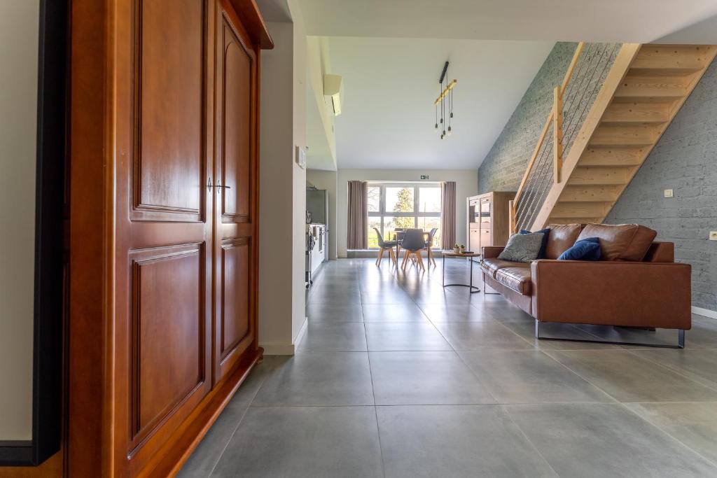 a living room with a couch and a staircase at De Hoog Velden 13 in Neerpelt