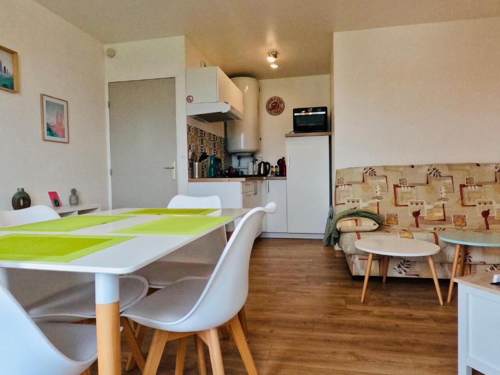uma cozinha e uma sala de estar com mesa e cadeiras em Appartement Cosy Joué-Les-Tours em Joué-lés-Tours