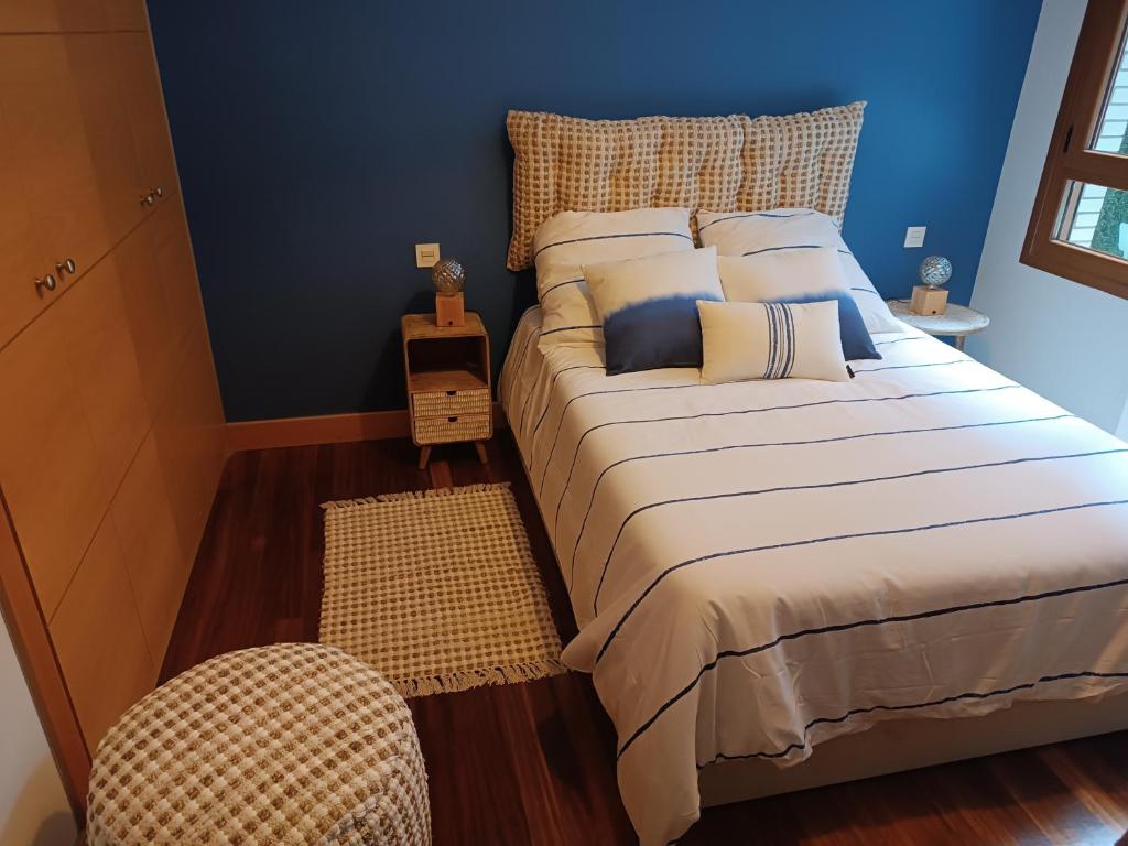 a bedroom with a large bed with blue walls at Karmelo junto al metro in Bilbao