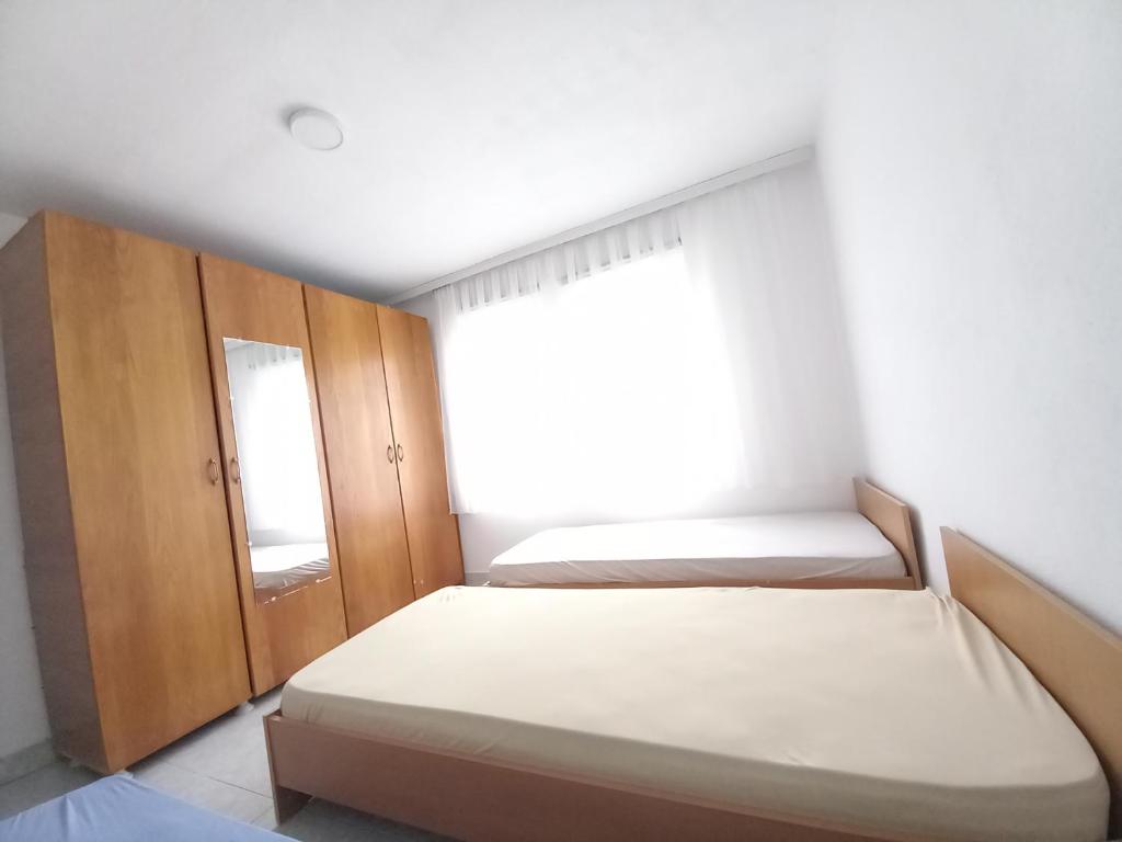 a small bedroom with two beds and a window at TOMI Apartment in Ulcinj