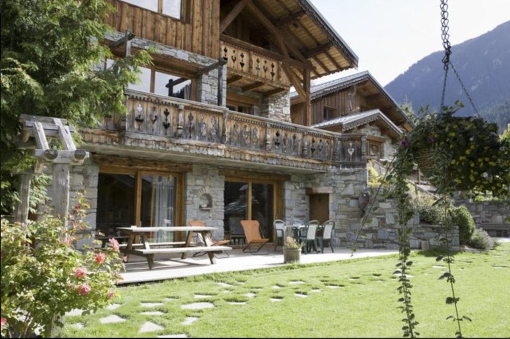 un grand bâtiment avec une table et des chaises dans une cour dans l'établissement Appartement 4 à 6 personnes aux portes du parc de la vanoise, à Champagny-en-Vanoise