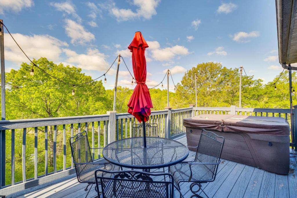 een tafel en stoelen op een terras met een paraplu bij Taylorsville Cottage with Hot Tub and Lake Access! in Taylorsville
