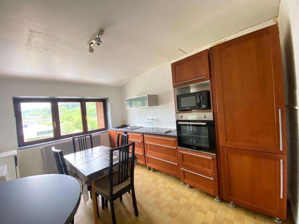 uma cozinha com uma mesa e uma sala de jantar em Appartement de 100 mc avec vue panoramique à 50 mn de Strasbourg. em Senones