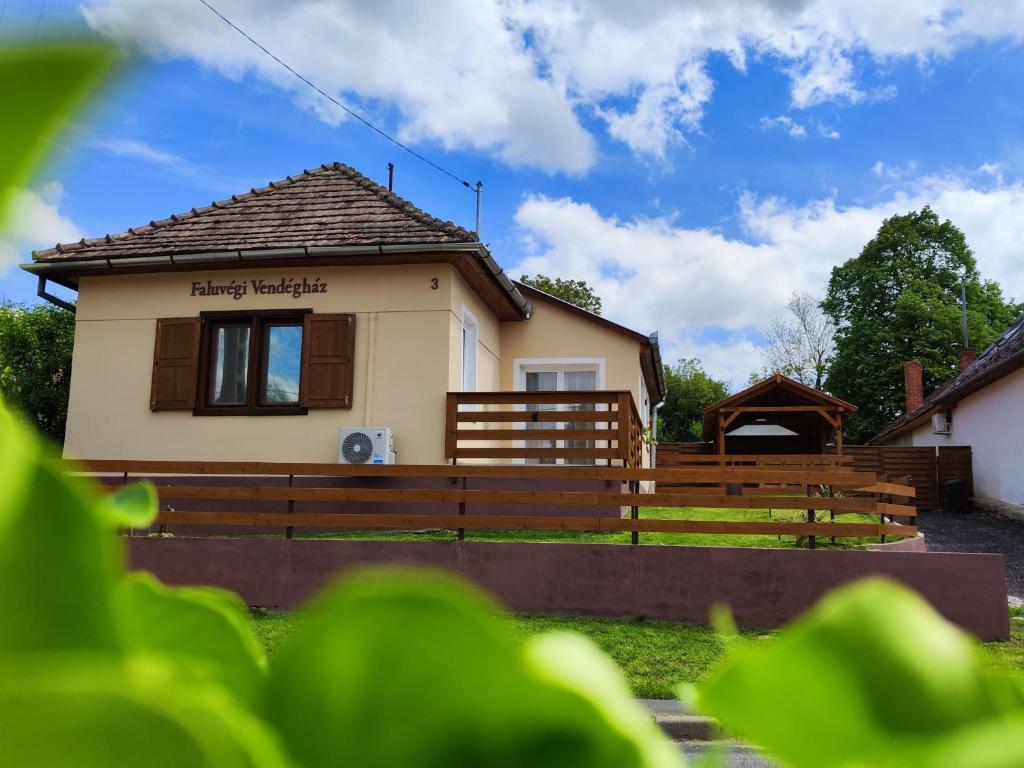 SzentgyörgyvárにあるFaluvégi Vendégház Szentgyörgyvárの木製の柵を前にした小さな家