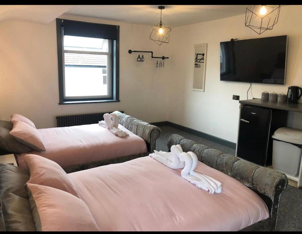 a living room with two beds and a flat screen tv at RESIDENCY LUXURY SEAFRONT HOTEL in Blackpool