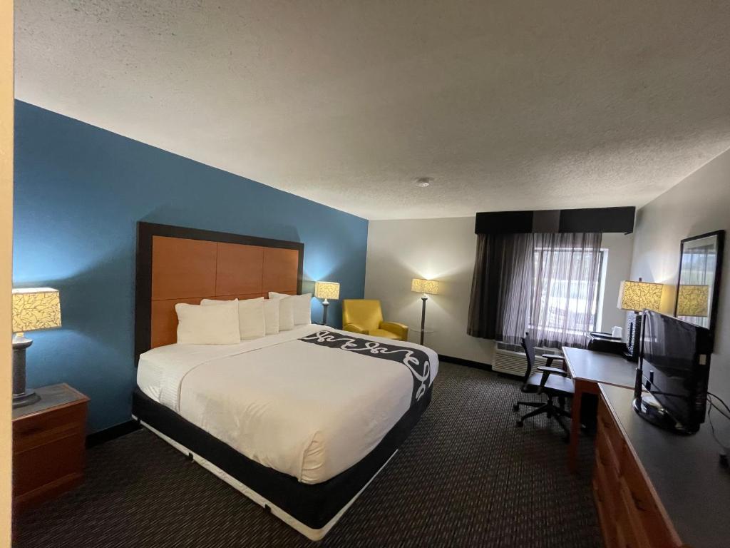 バトンルージュにあるLa Quinta by Wyndham Baton Rouge Siegen Laneの大きなベッドとデスクが備わるホテルルームです。