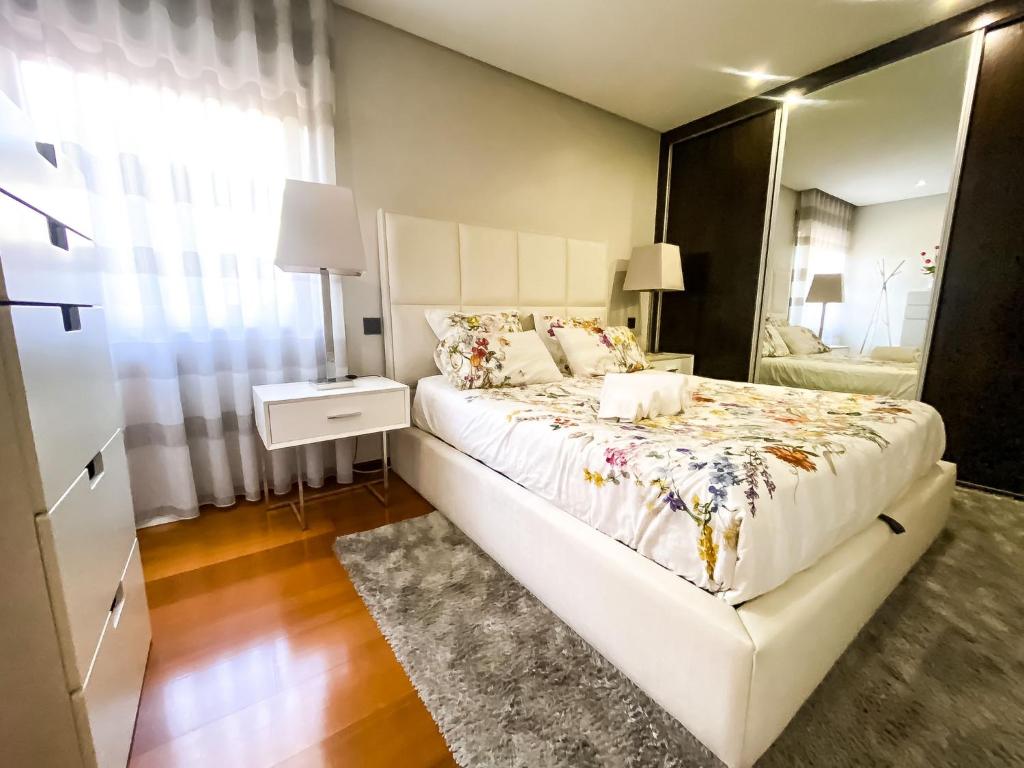 um quarto com uma cama grande e um espelho em Mar&Sal Vila do Conde em Vila do Conde