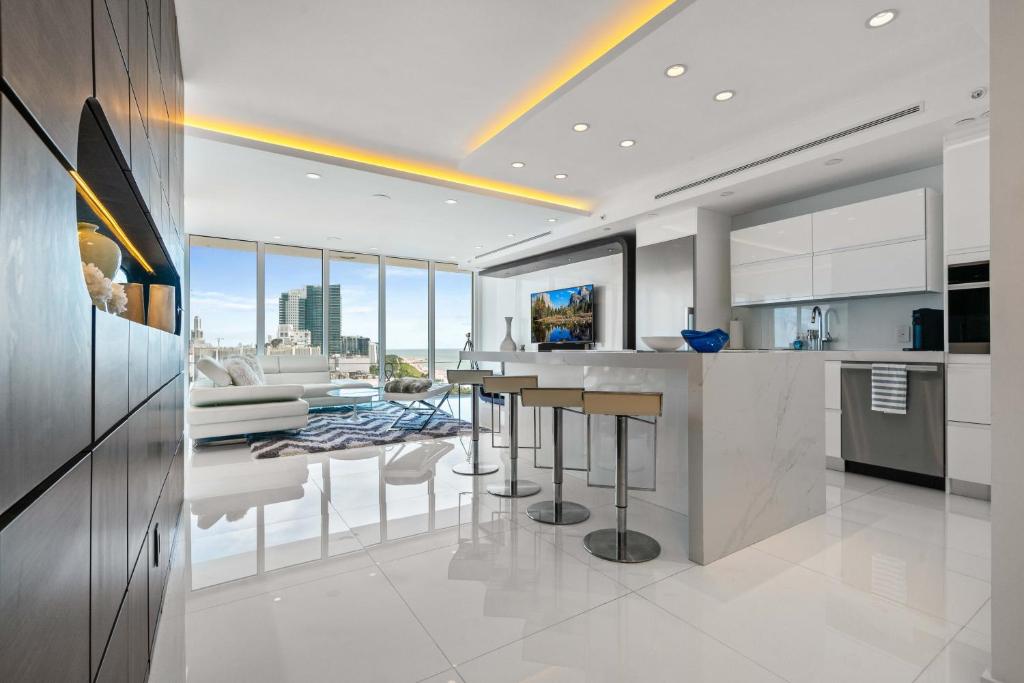 een keuken met witte apparatuur en een woonkamer bij Oceanview Penthouse Condo at Decoplage -PH6 in Miami Beach