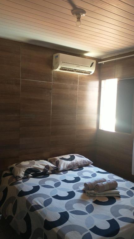 1 dormitorio con 1 cama en una habitación con ventilador en Suites Jatiuca en Maceió