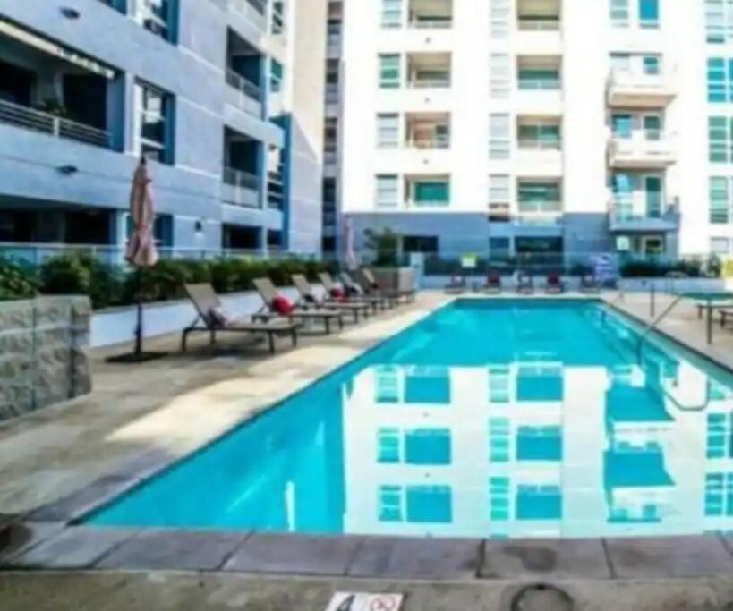 una grande piscina con sedie e un edificio di 2bedroom Downtown Los Angeles pool and gym onsite. a Los Angeles