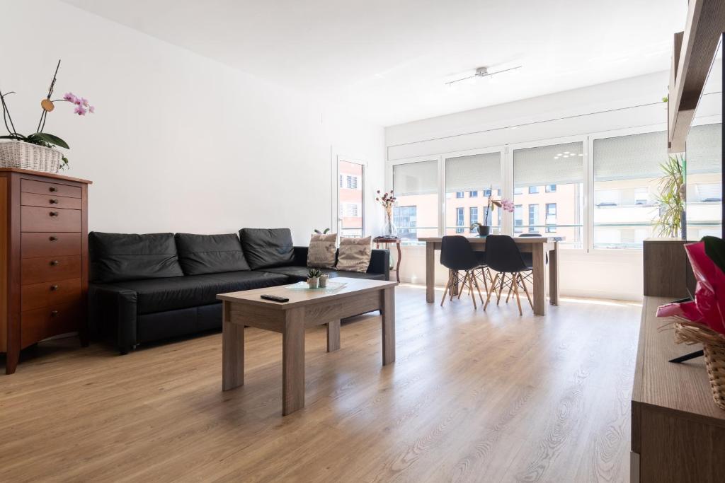 uma sala de estar com um sofá e uma mesa em Apartment Granollers Up Live II em Granollers