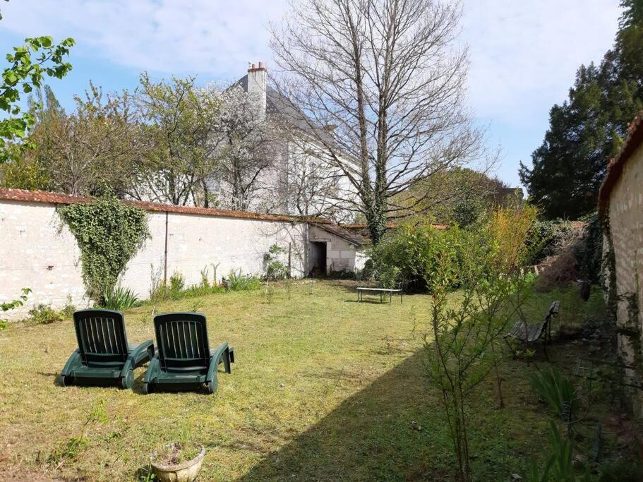 two chairs sitting in the yard of a house at La Volière in Champigny-sur-Veude