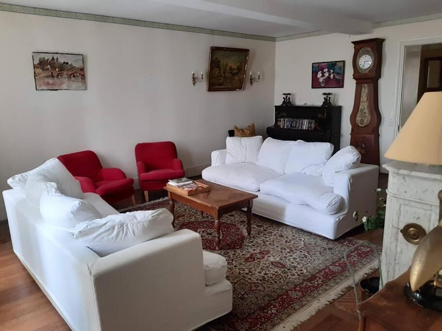 a living room with white couches and red chairs at La Volière in Champigny-sur-Veude