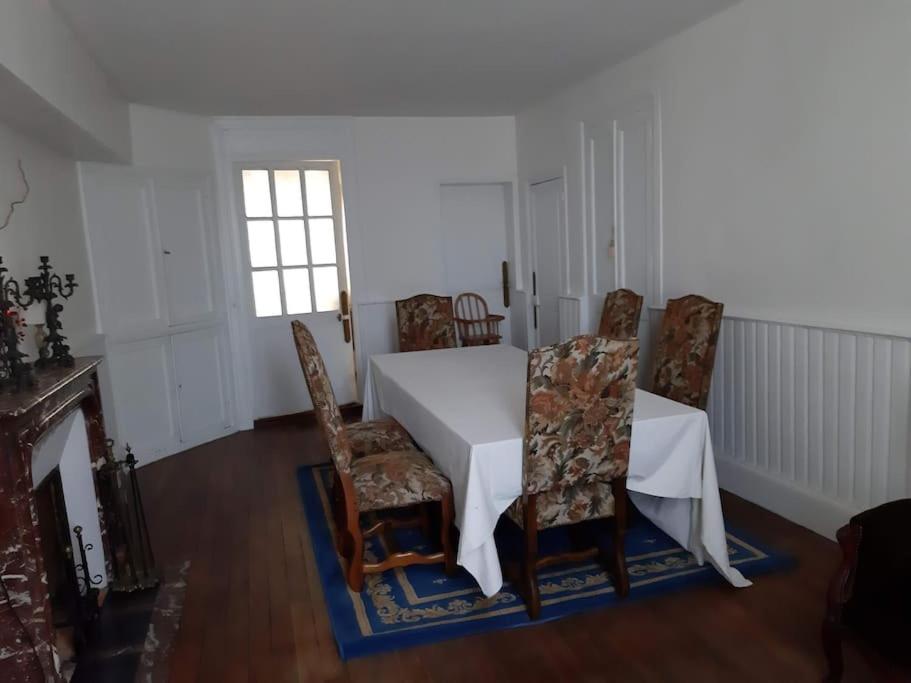 a dining room with a white table and chairs at La Volière in Champigny-sur-Veude