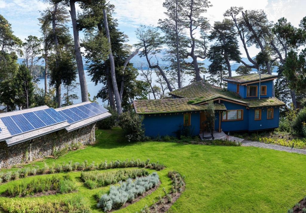 a house with solar panels and a garden at Savia Madre Eco-lodge in Villa La Angostura