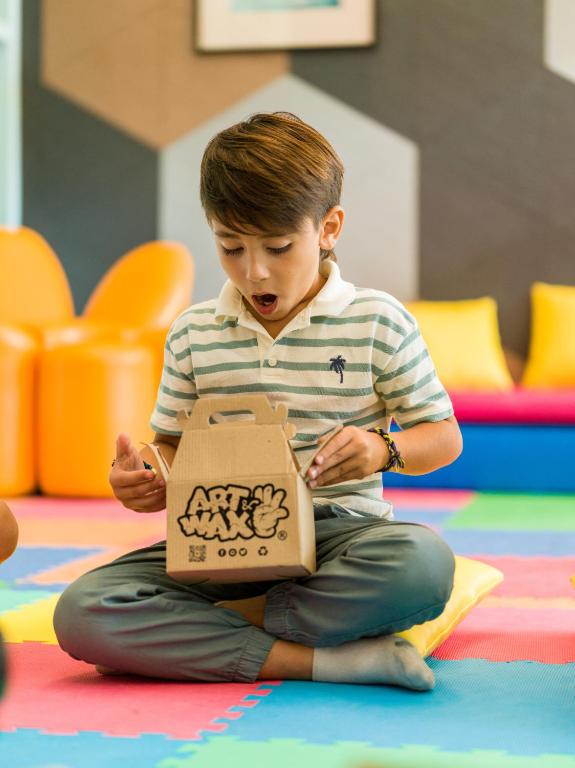 a young boy sitting on the floor with a bag at Paradisus Cancun All Inclusive in Cancún