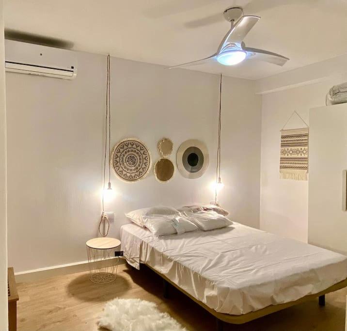 um quarto branco com uma cama e uma ventoinha de tecto em magnífica y moderna vivienda em Caravaca de la Cruz