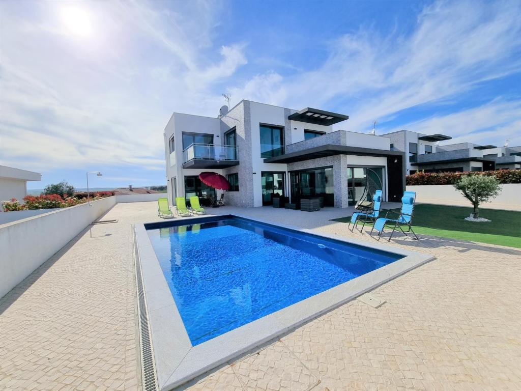 a large house with a swimming pool in front of it at Villa Joia in Bombarral