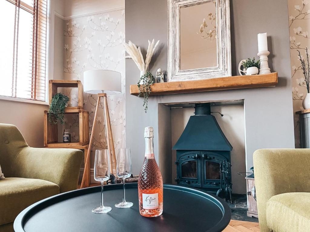 eine Flasche Champagner auf dem Tisch im Wohnzimmer mit Kamin in der Unterkunft Ty-Fry House, by Solace Stays in Cardiff