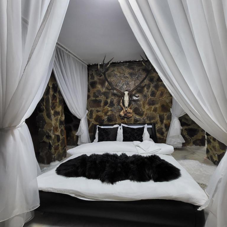 1 dormitorio con 1 cama grande de piel negra en Cabana Ana en Petroşani