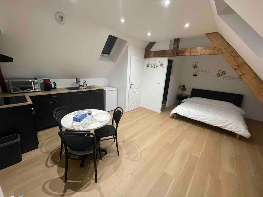Zimmer mit einem Tisch, Stühlen und einem Bett in der Unterkunft Studio à Centre ville de BRIVE LA GAILLARDE in Brive-la-Gaillarde