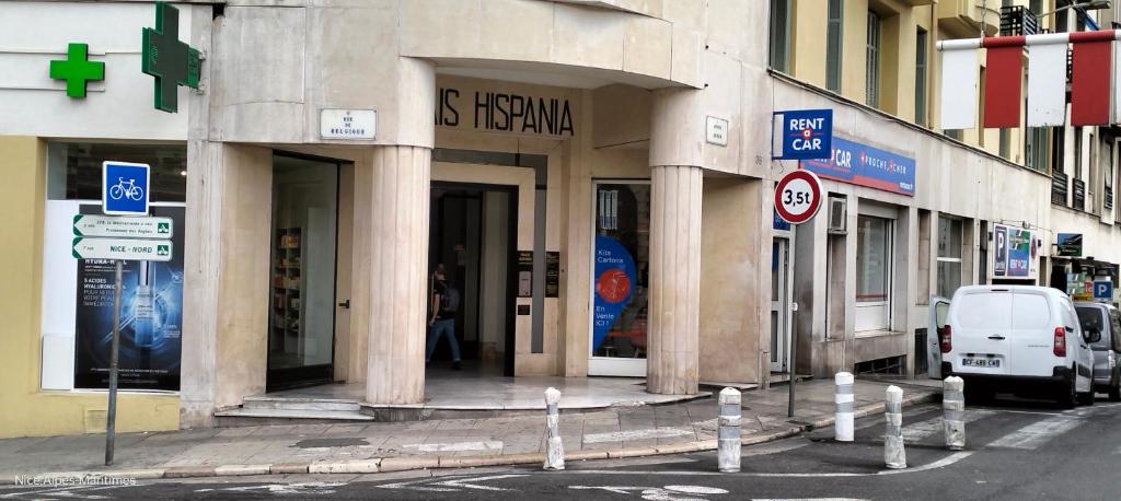 een gebouw met kolommen aan een straat met een busje ernaast geparkeerd bij Central Station apartment in Nice